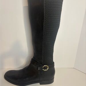 This is a pair of Cole Haan Leela Grand Riding Boots in black leather.